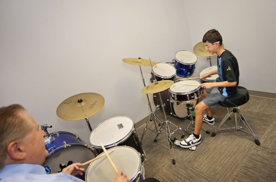 drum student with instructor in a lesson.