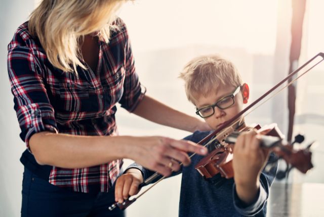 student learning how to play the violin with a teacher Orland Park IL
