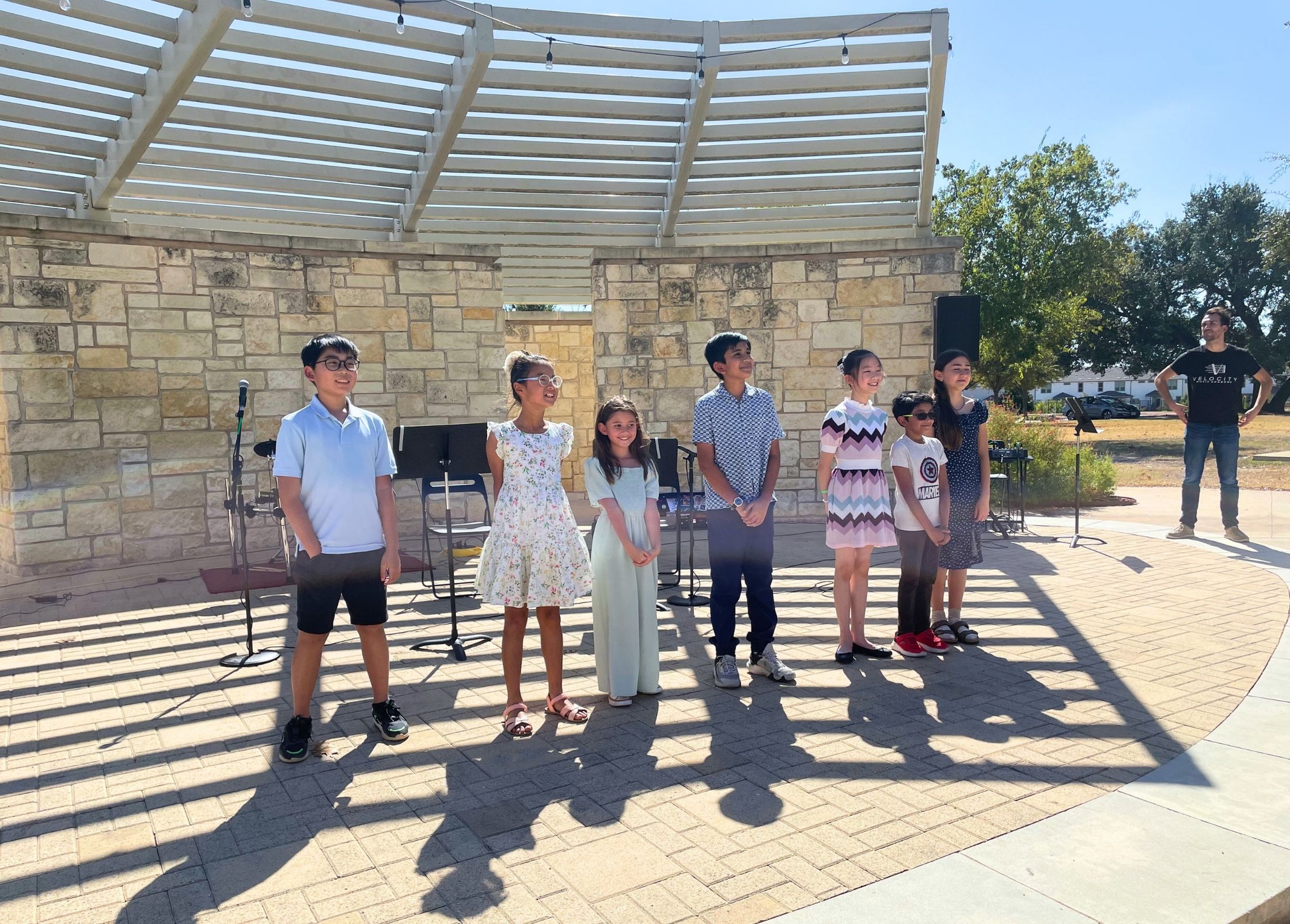 kids smiling at an outdoor stage