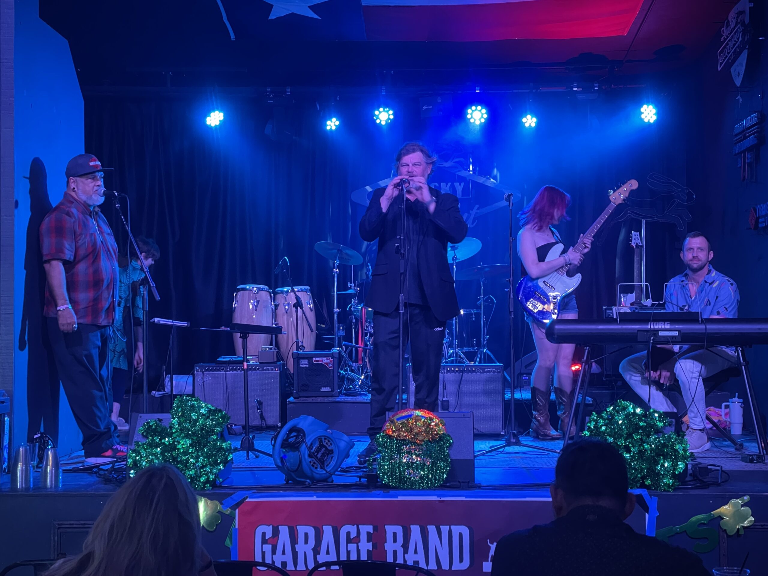 a rock band made of adult students on stage with a blue light background