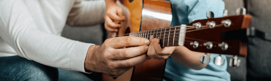 guitar teacher helping the student