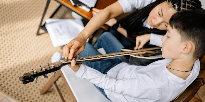 student taking an in-home guitar lesson