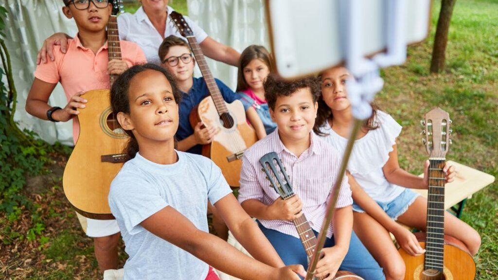 kids at a summer music camp taking a selfie with their guitars