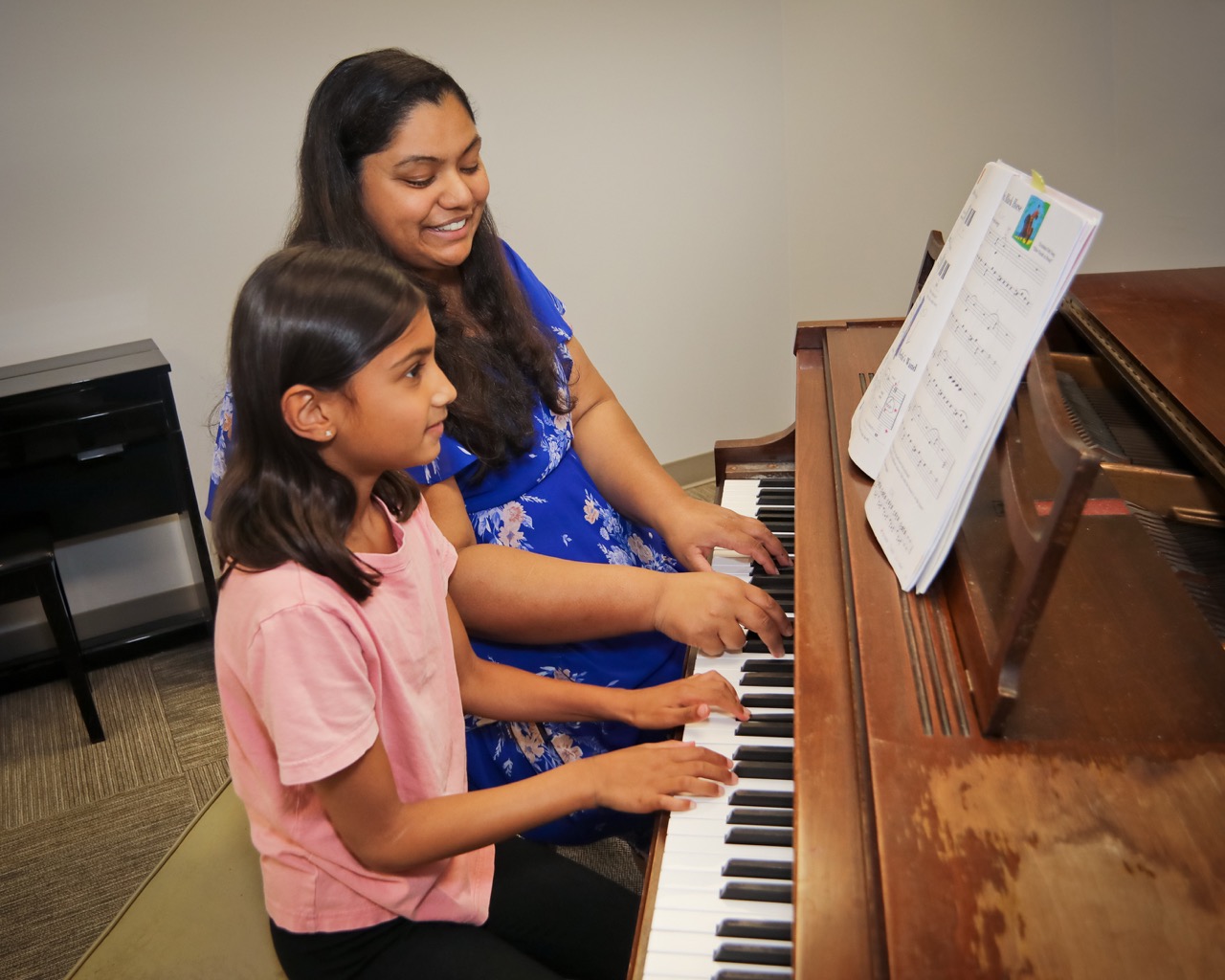 piano teacher and student playing together in a lesson