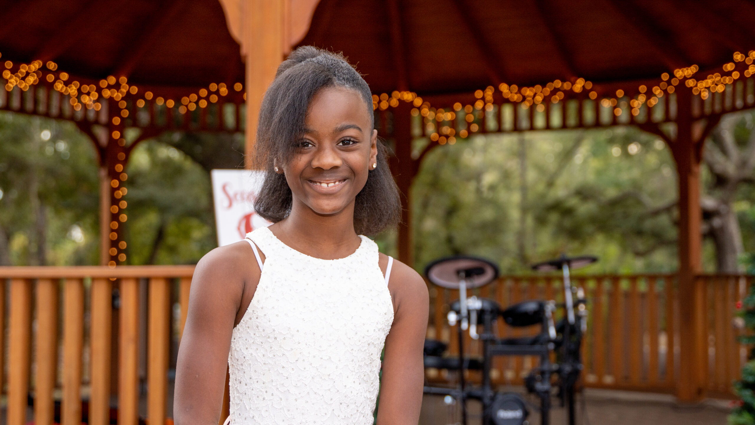 smiling student in front of a pagoda during a recital