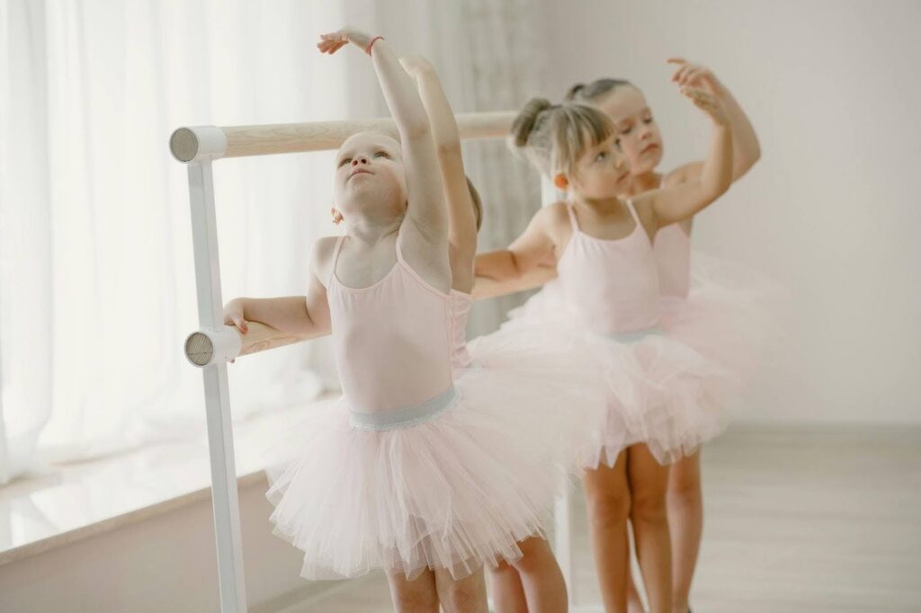 Toddler ballerinas standing at ballet bar