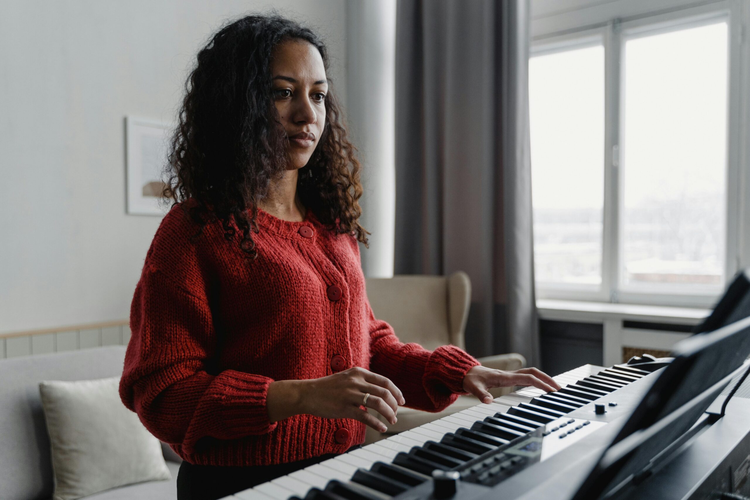 Woman in a red sweater playing the piano